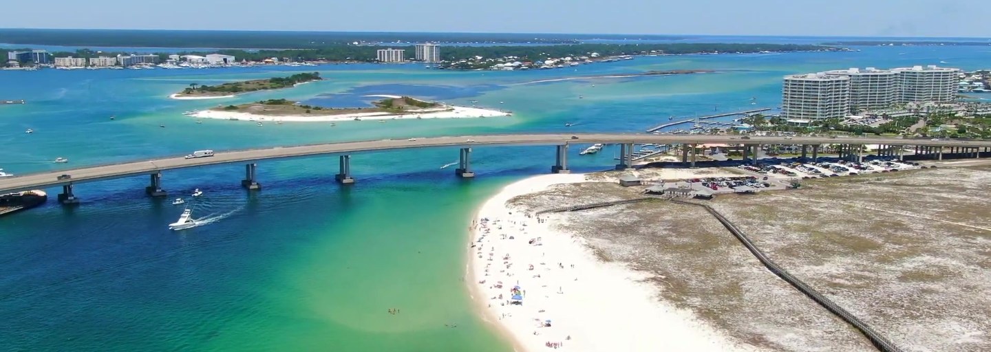 Aerial view of the bridge, white sand beach and turquoise water at Perdido Pass