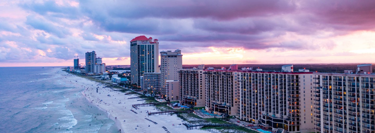 Beachfront condo towers on the white sand beach and Gulf at sunset in Gulf Shores, Alabama