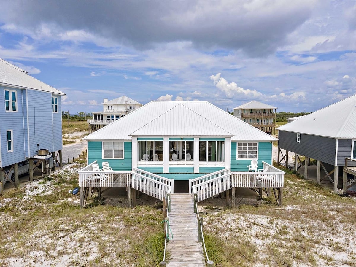 Teal beach house with front porch at Bairds Blue Dolphin in Fort Morgan, Alabama