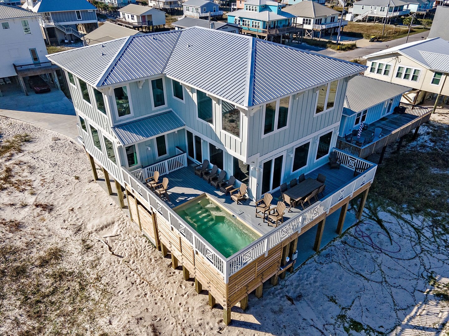 Aerial view of a beachfront house with a deck and plunge pool