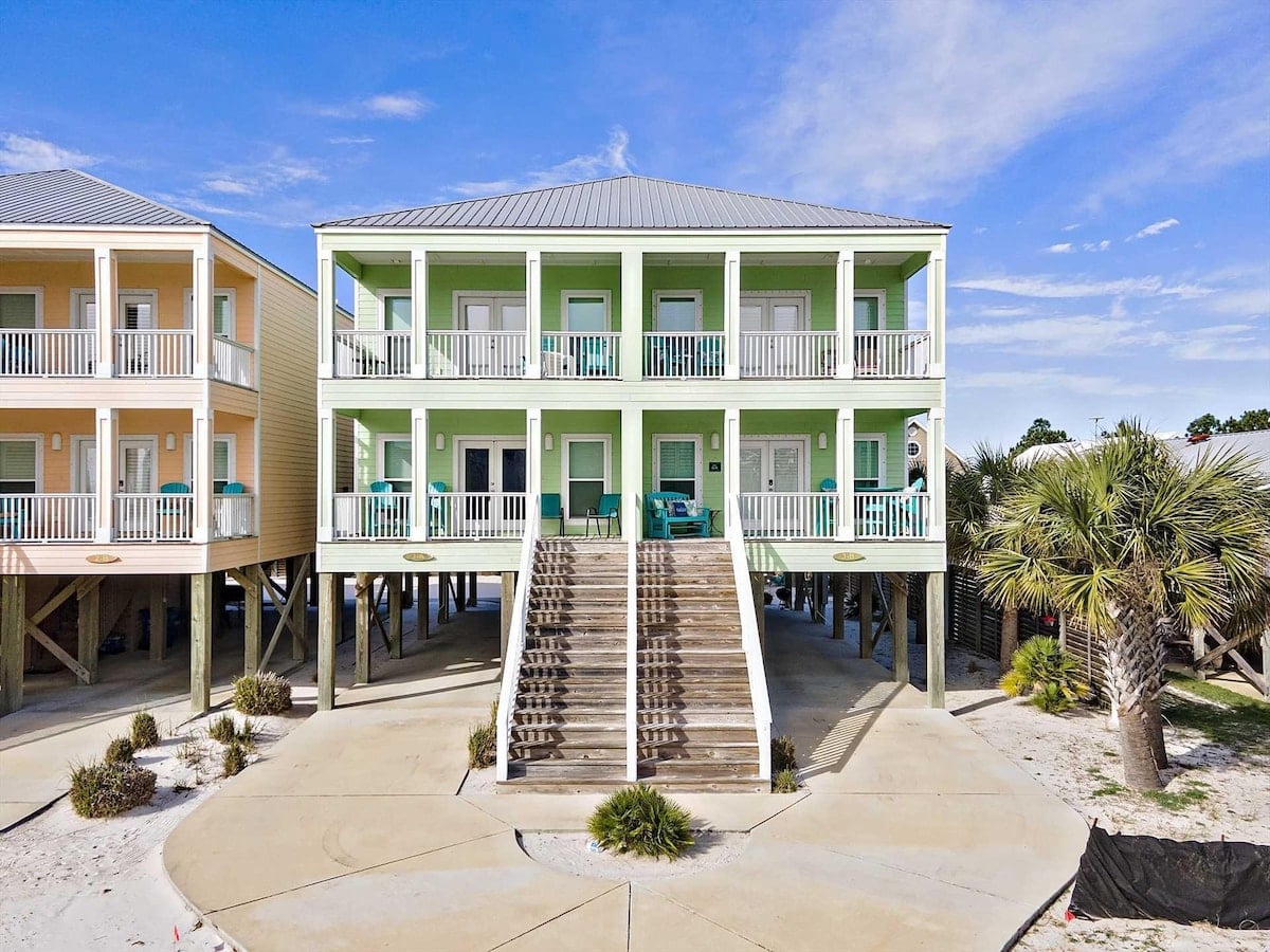 Green beach house with twin staircases at Mintal Escape in Gulf Shores, Alabama