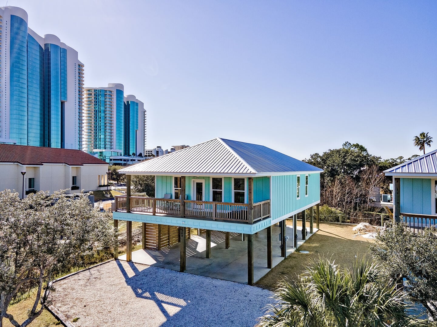 Teal cottage on stilts at Orange Beach Cottage South in Orange Beach, Alabama
