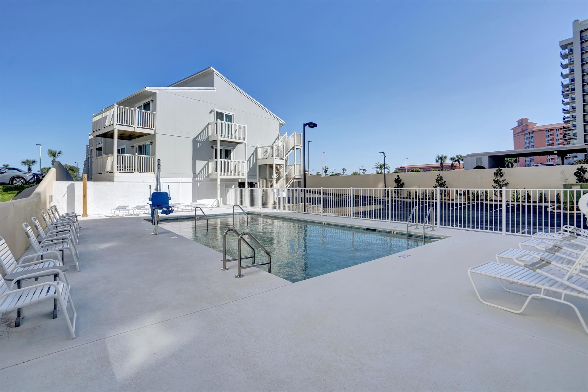 Outdoor pool and lounge chairs at Perdido Dunes Tower in Orange Beach, Alabama