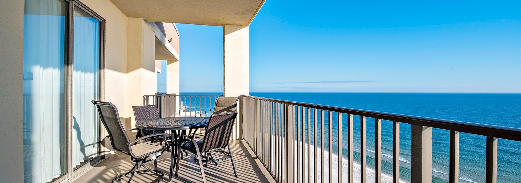 Balcony with a table and chairs and a wide Gulf view at Phoenix IV (Phoenix 4) in Orange Beach, Alabama